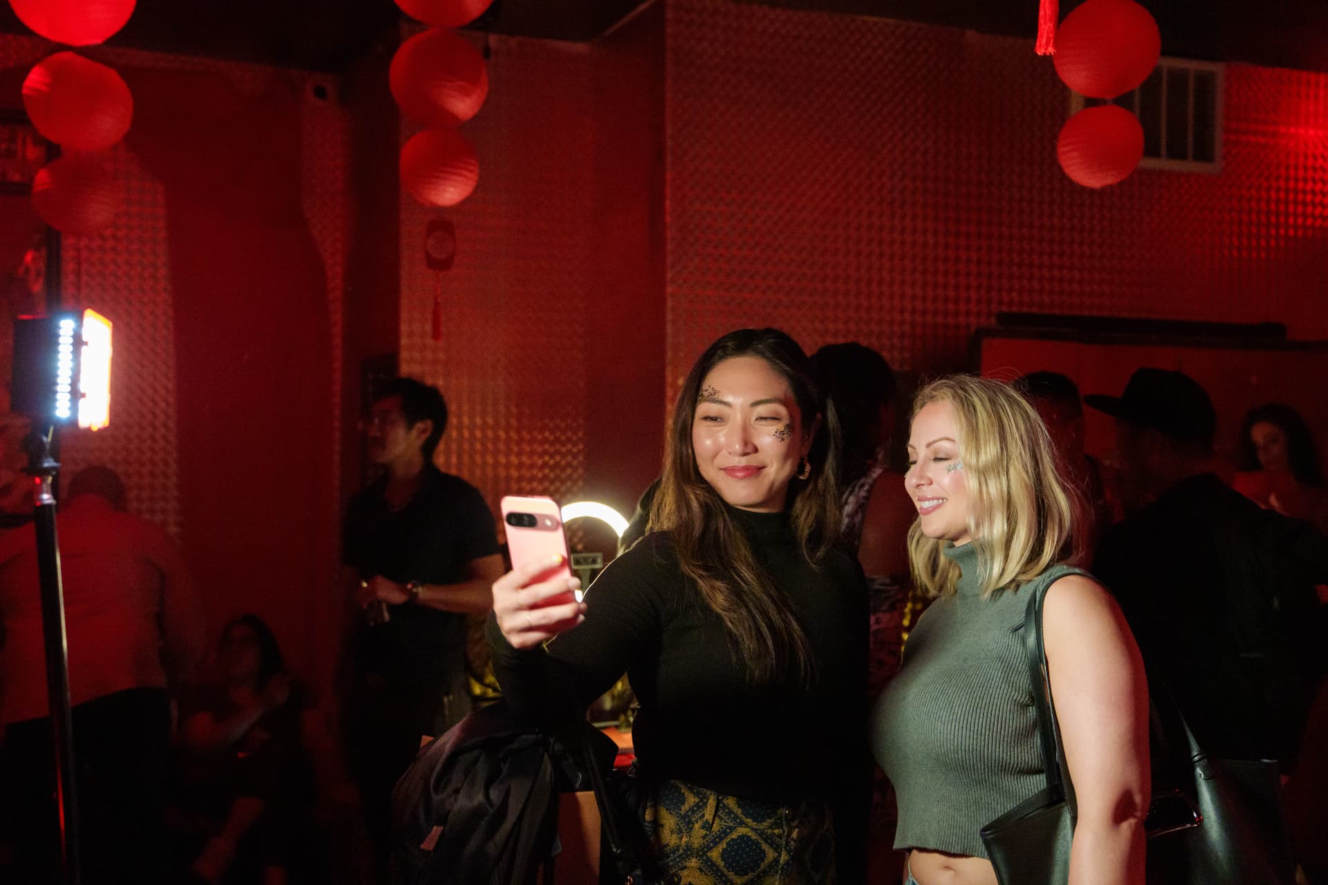 Two guests taking a selfie under red lanterns at the venue