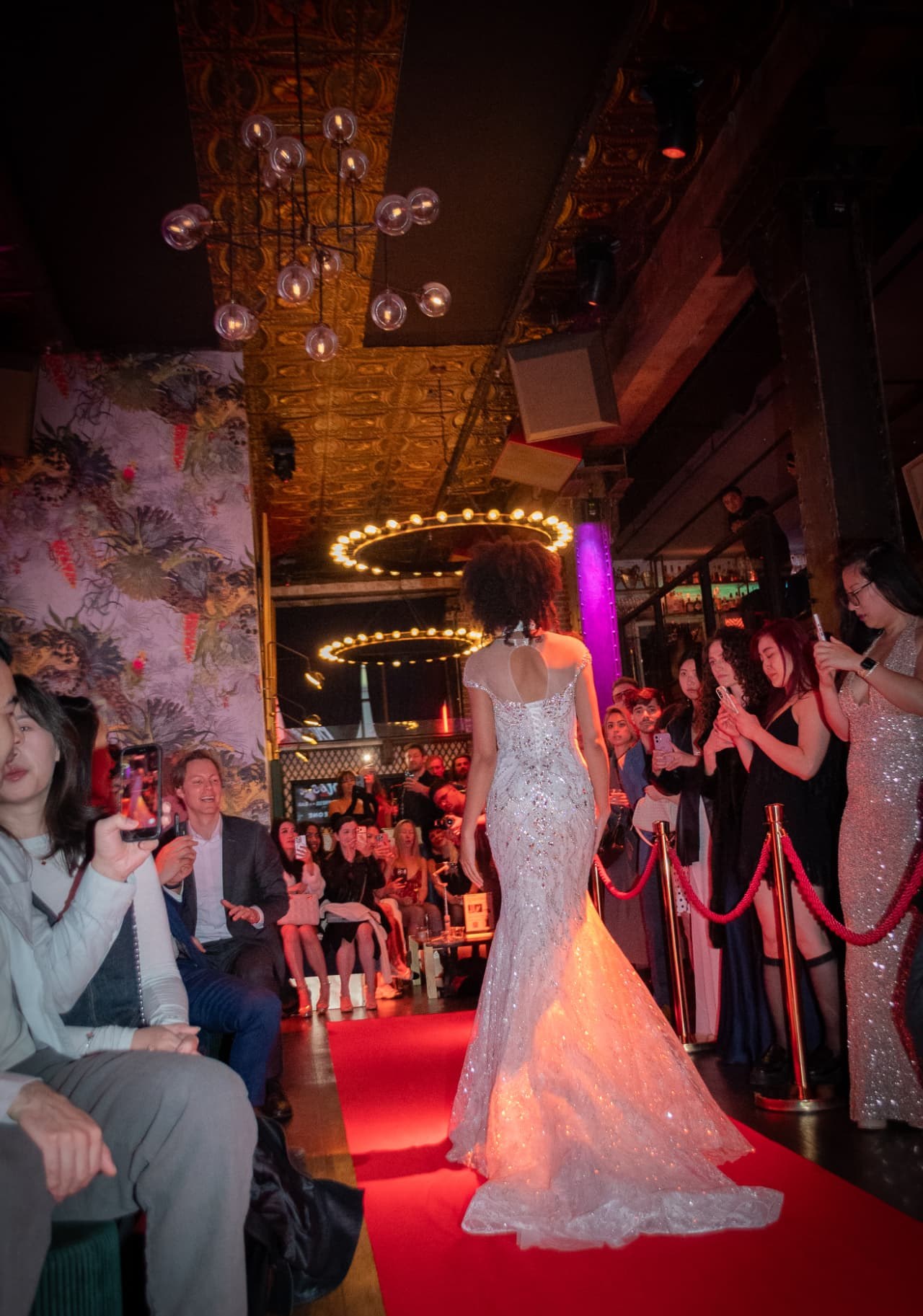A model in a crystal-embellished gown walking the red-carpet runway