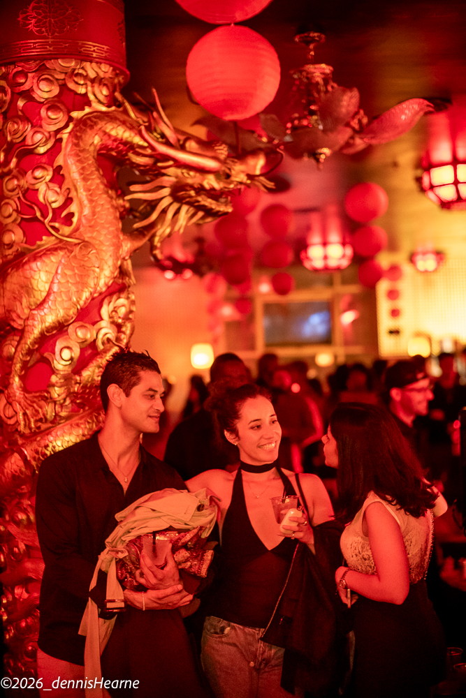 Guests mingling beside a gold dragon column under red lanterns