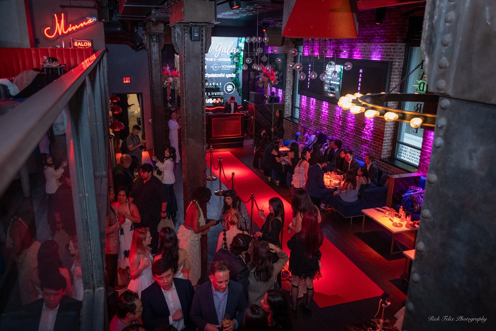 Guests networking under magenta stage lighting