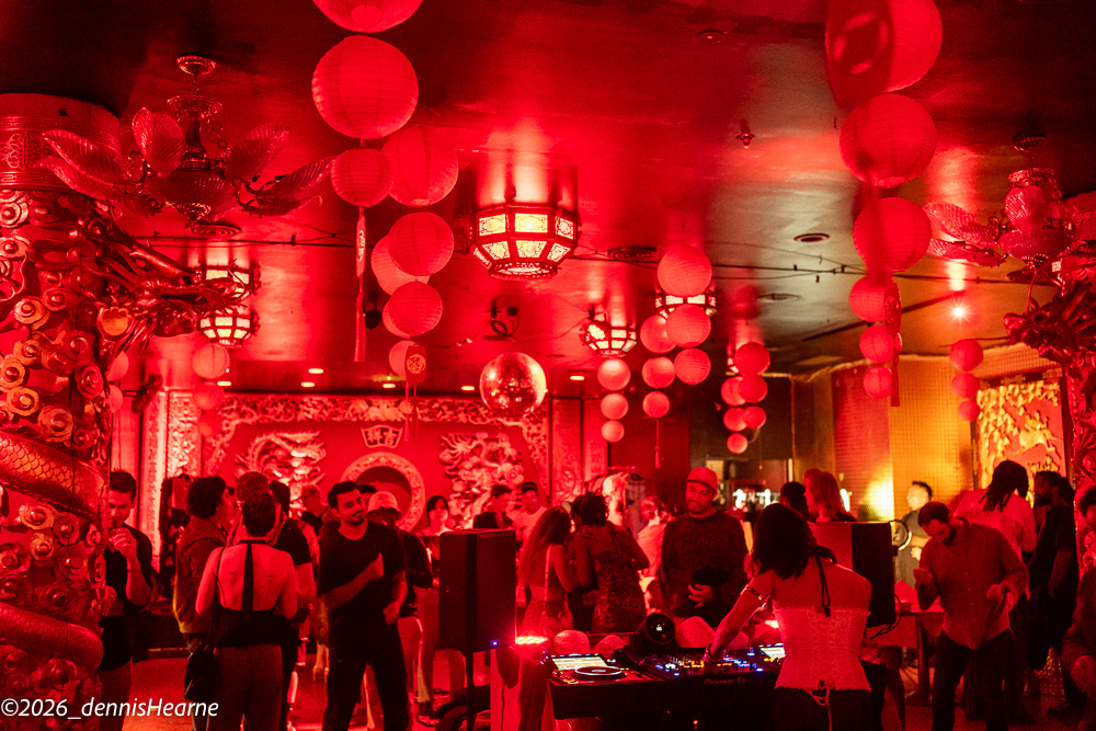 Red-lit venue filled with guests during a community activation