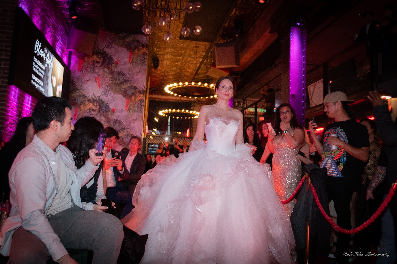 Guests photographing a couture bridal look on the runway